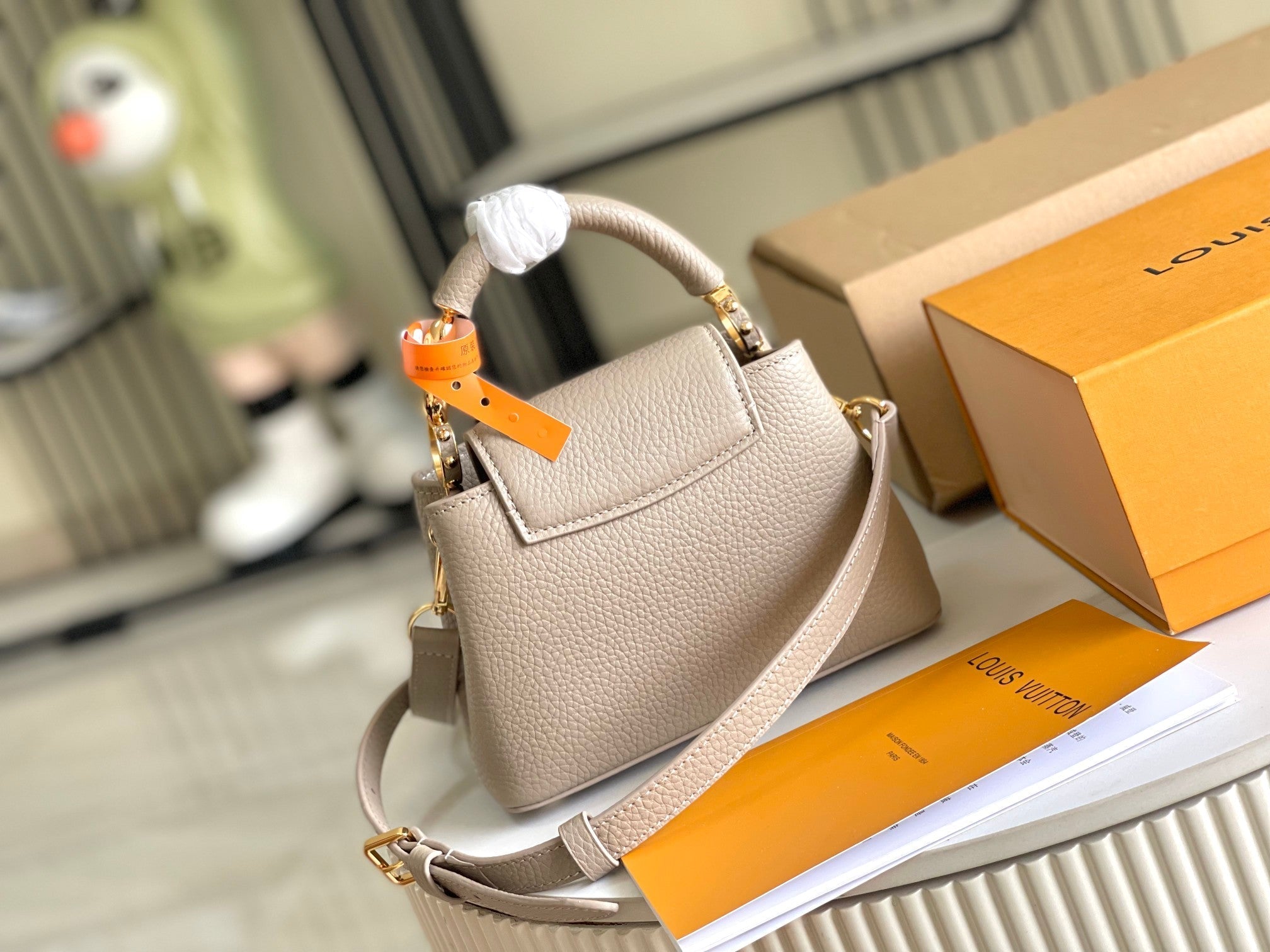 CAPUCINES MINI 21 DARK BEIGE TAURILLON GOLD HARDWARE